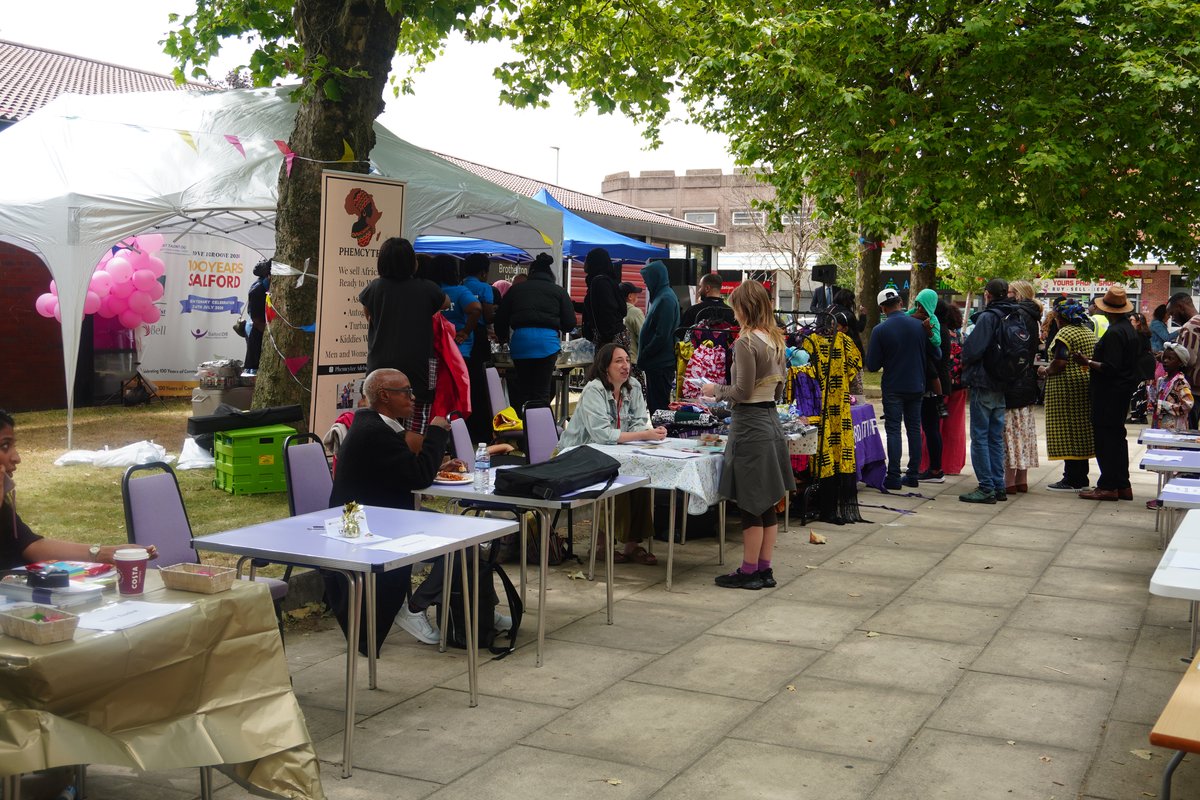 Residents mingling and exploring partner exhibition stalls under the outdoor gazebos