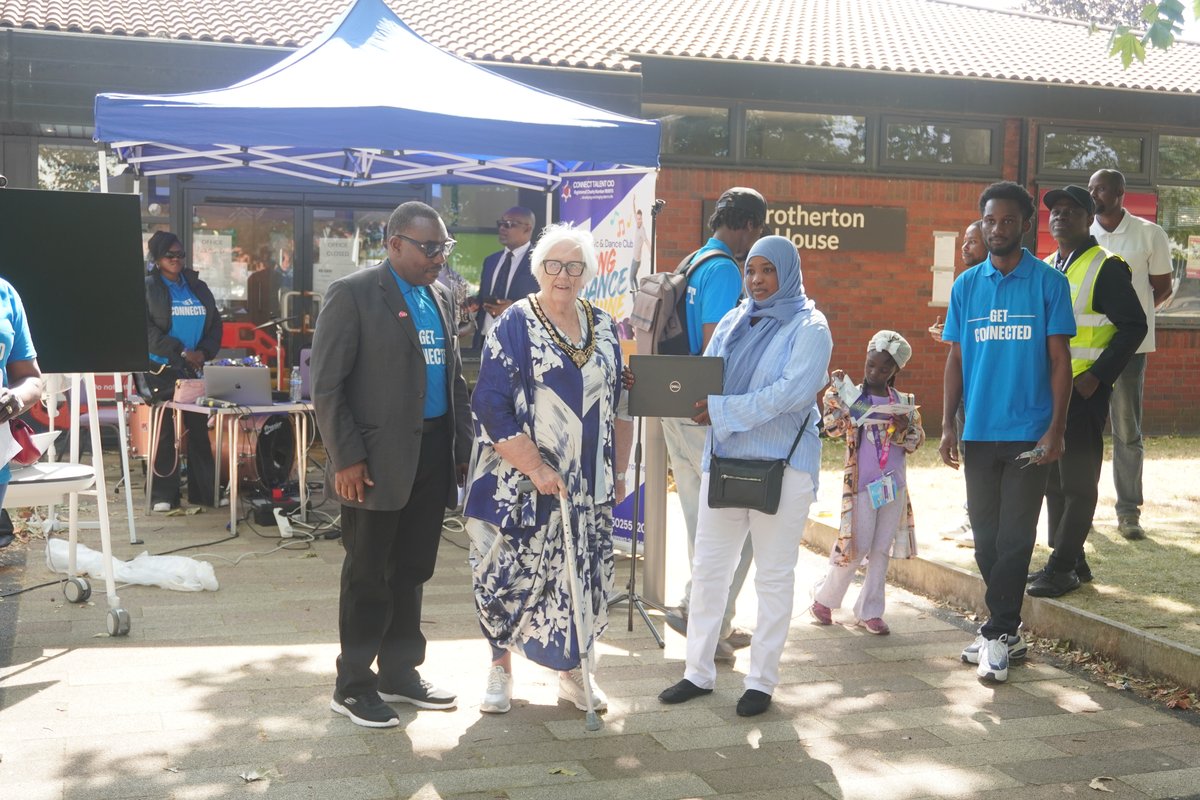 An outstanding Essential Digital Skills learner joyfully receiving her brand new laptop outside Brotherton House with CEO Dr. Ola Ojerinola & the Mayoress Karen Garrido