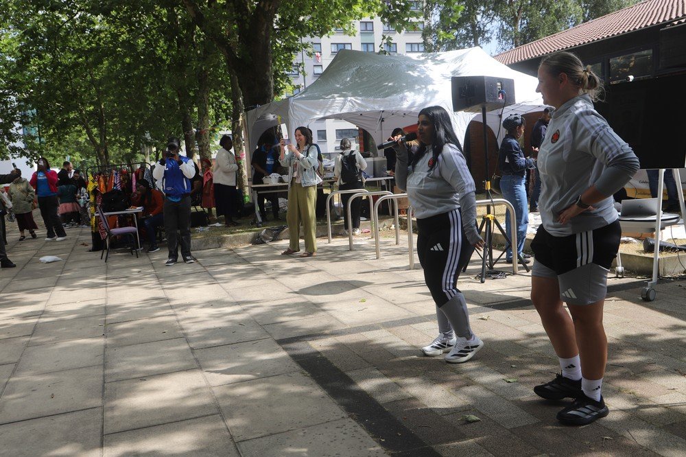 Two fantastic coaches from Salford City FC directing the community movement and stretching exercises with microphones in hand