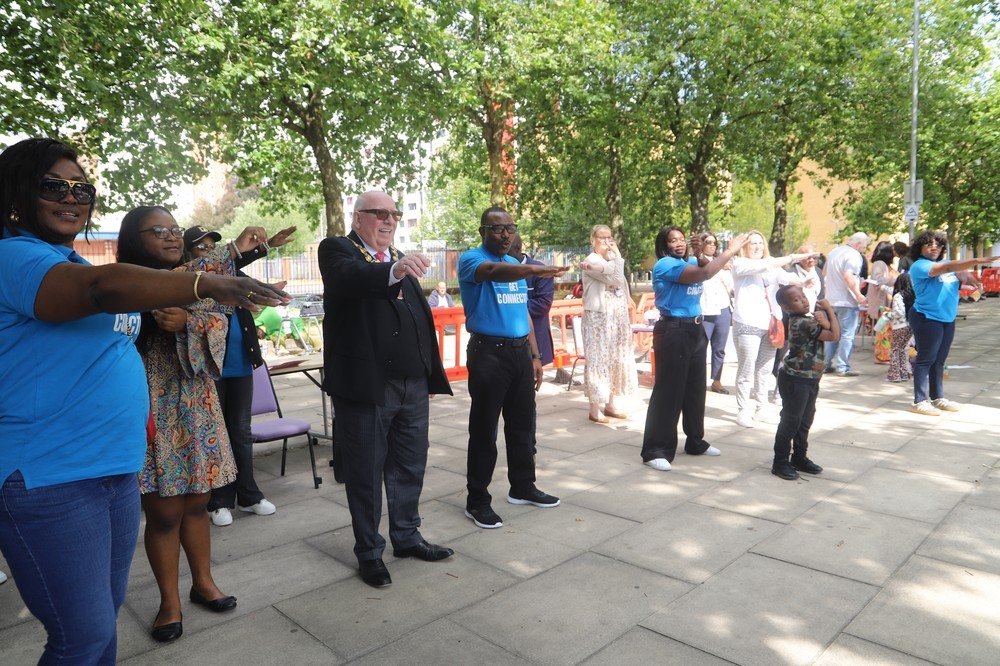 Ceremonial Mayor Robin Garrido, Connect Talent staff, and community members participating together in the Salford City FC arm stretching exercises