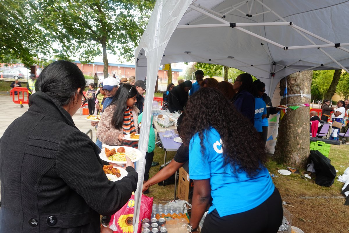 Community members gathering around tables to enjoy culturally diverse culinary delights and refreshments