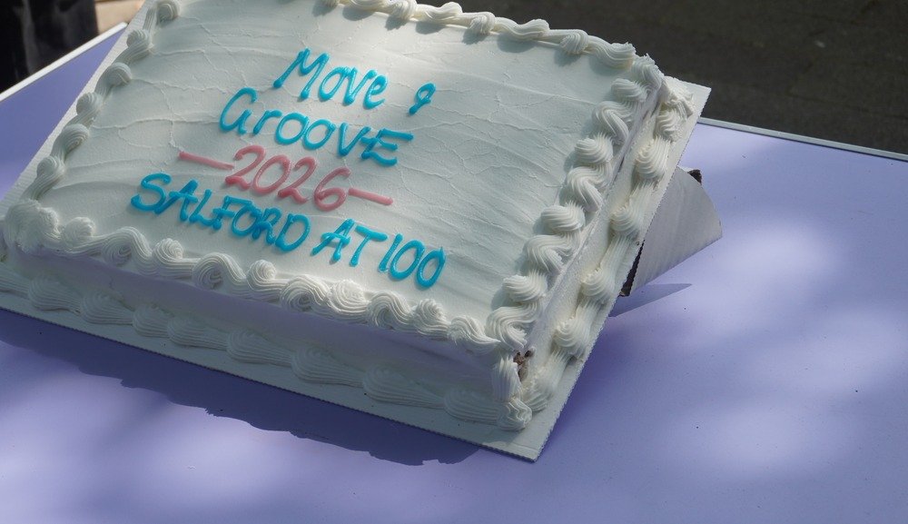 Clean cropped close-up of the official Salford at 100 celebratory centenary cake resting gracefully on the table