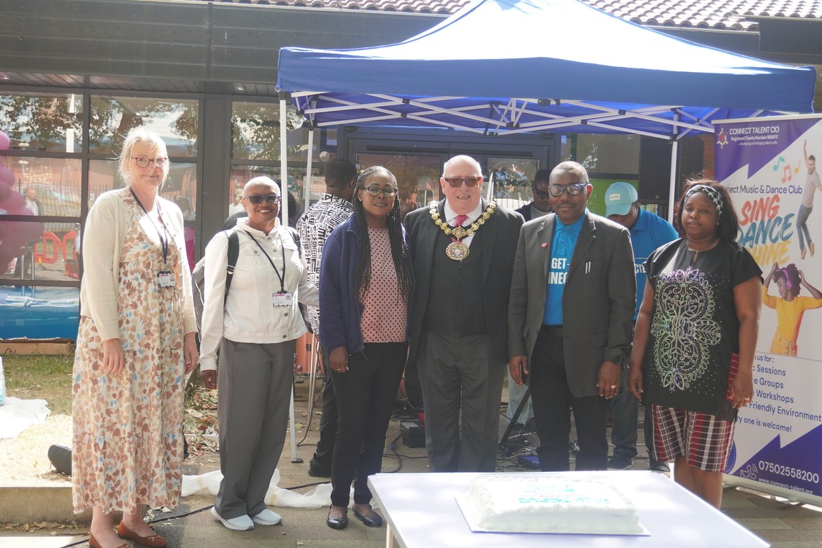 Connect Talent CIO CEO Dr. Ola Ojerinola and the Ceremonial Mayor of Salford, Councillor Robin Garrido, standing proudly alongside our incredible community partners by the centenary cake